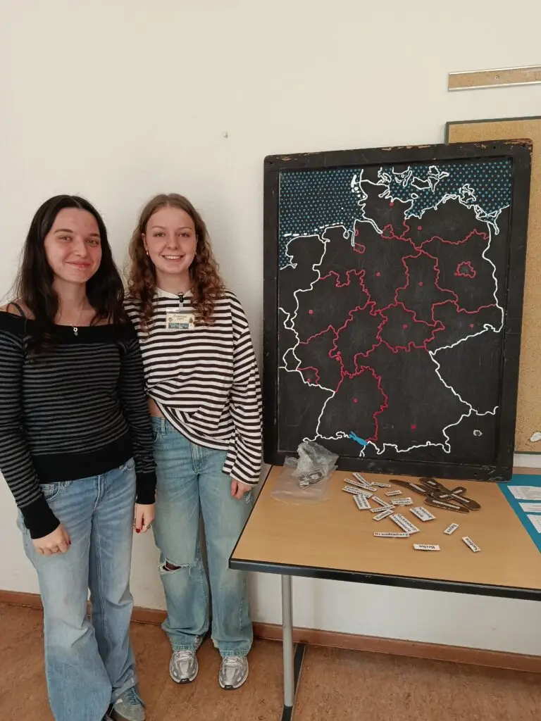 Zwei Personen am Präsentationstisch vor einer Europakarte