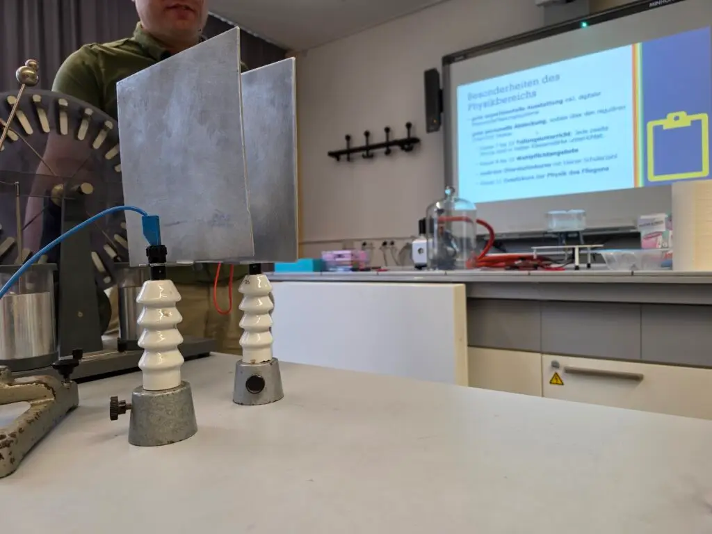 Physikversuch mit Metallplatten und Isolatoren im Fachraum
