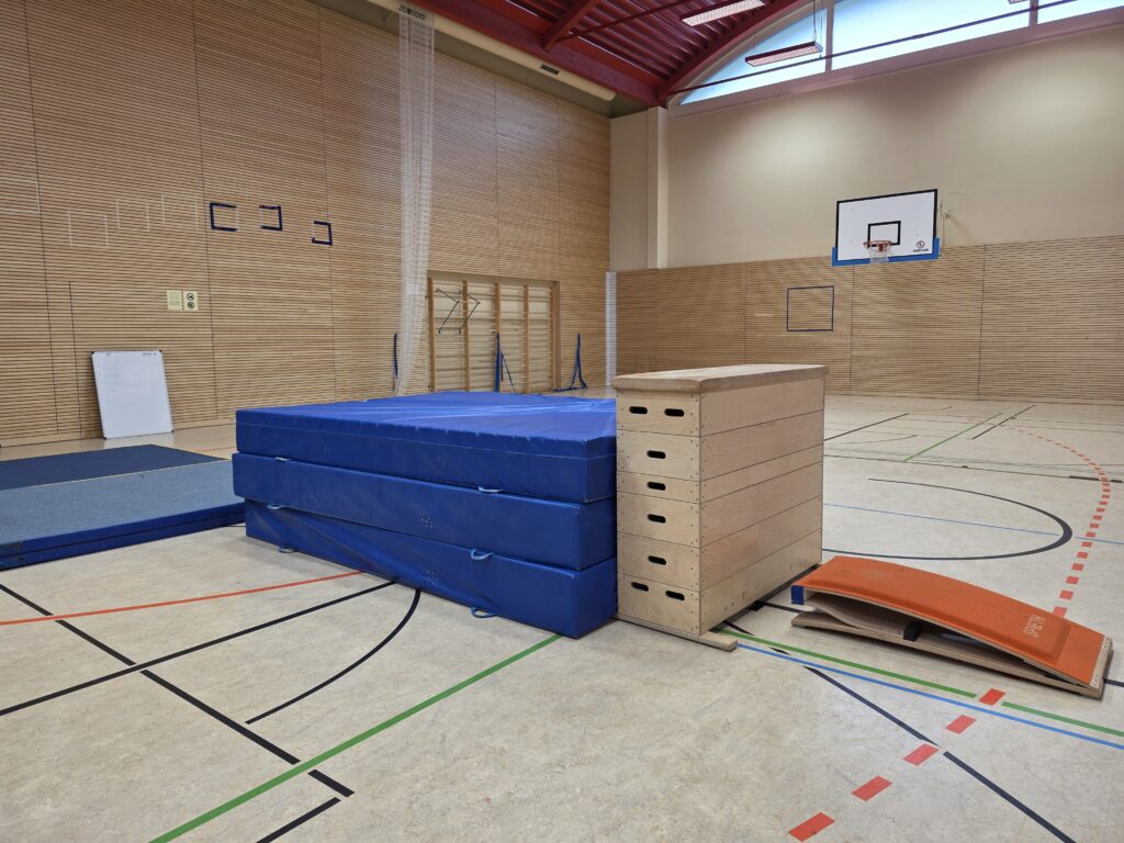 Geräteaufbau mit Turnmatten, Sprungkasten und Sprungbrett in der Sporthalle